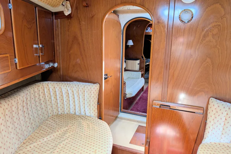 Iteration Yacht Photos Pics Interior of 1994 Amel 53 Super Maramu yacht with wood paneling and cozy seating.