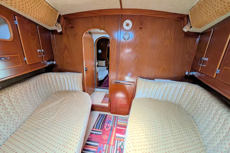 Iteration Yacht Photos Pics Interior of 1994 Amel 53 Super Maramu yacht with cozy seating and wooden paneling.