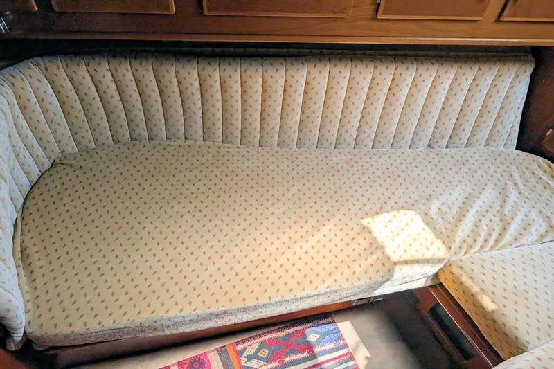 Iteration Yacht Photos Pics 1994 Amel 53 Super Maramu yacht interior with cushioned seating and wooden paneling.