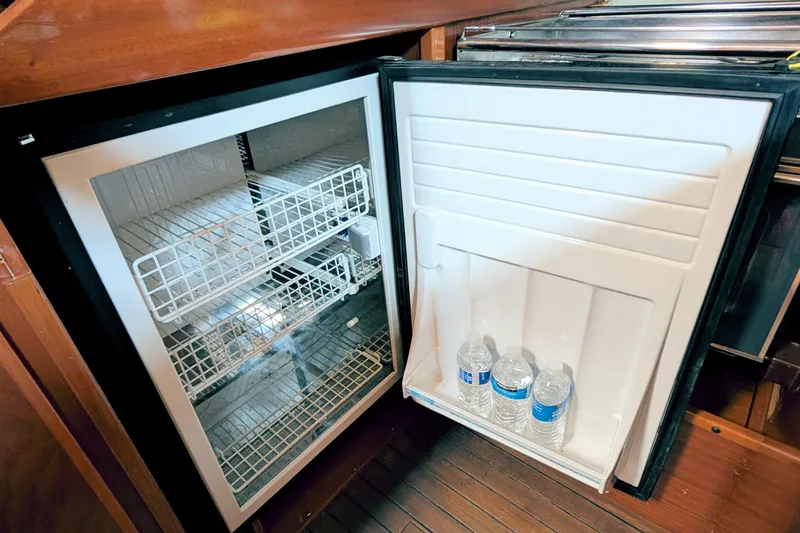 Iteration Yacht Photos Pics Open fridge on 1994 Amel 53 Super Maramu yacht with water bottles inside.