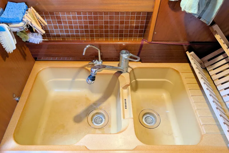 Iteration Yacht Photos Pics Double sink in 1994 Amel 53 Super Maramu yacht kitchen with wooden accents.