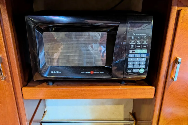 Iteration Yacht Photos Pics GoldStar microwave in wooden cabinet on 1994 Amel 53 Super Maramu yacht.