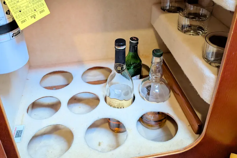 Iteration Yacht Photos Pics Liquor cabinet on 1994 Amel 53 Super Maramu yacht with bottles and glasses.