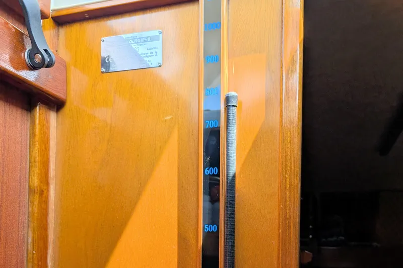 Iteration Yacht Photos Pics Interior of 1994 Amel 53 Super Maramu yacht with wooden paneling and measurement gauge.