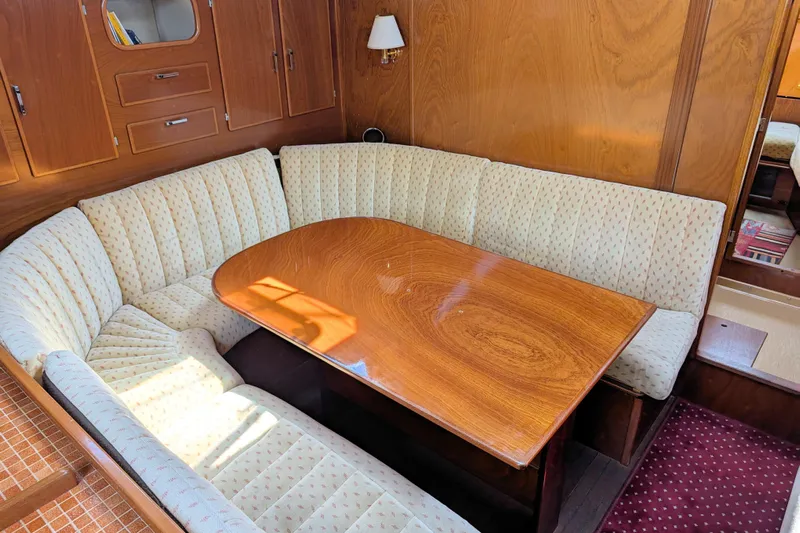 Iteration Yacht Photos Pics Interior of 1994 Amel 53 Super Maramu yacht with cozy dining area and wooden table.