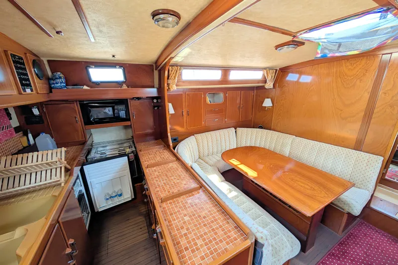 Iteration Yacht Photos Pics Interior of 1994 Amel 53 Super Maramu yacht with cozy seating and wooden finishes.