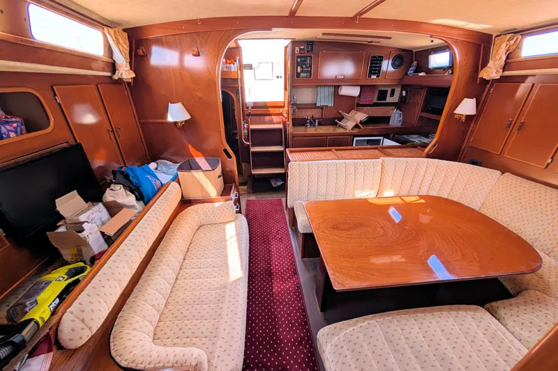 Iteration Yacht Photos Pics Interior of 1994 Amel 53 Super Maramu yacht with cozy seating and wooden table.