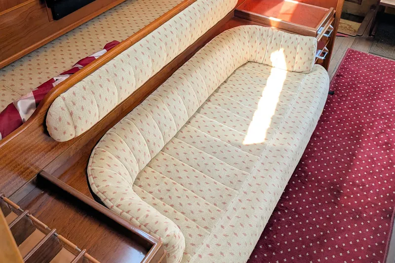 Iteration Yacht Photos Pics Interior of 1994 Amel 53 Super Maramu yacht with patterned seating and red carpet.