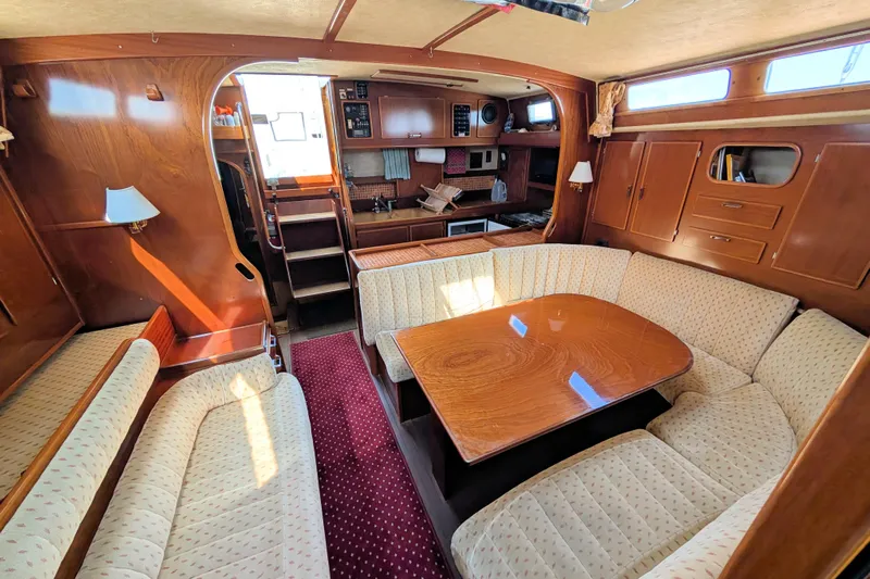 Iteration Yacht Photos Pics Interior of 1994 Amel 53 Super Maramu yacht with cozy seating and wooden table.