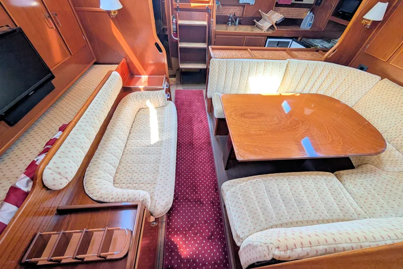 Iteration Yacht Photos Pics Interior of 1994 Amel 53 Super Maramu yacht with cozy seating and wooden table.
