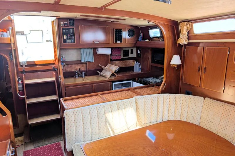 Iteration Yacht Photos Pics Interior of 1994 Amel 53 Super Maramu yacht with wooden cabinetry and cozy seating area.