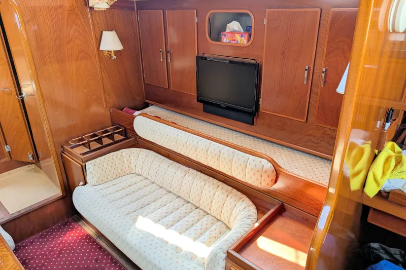 Iteration Yacht Photos Pics Interior of 1994 Amel 53 Super Maramu yacht with cozy seating and wooden cabinetry.