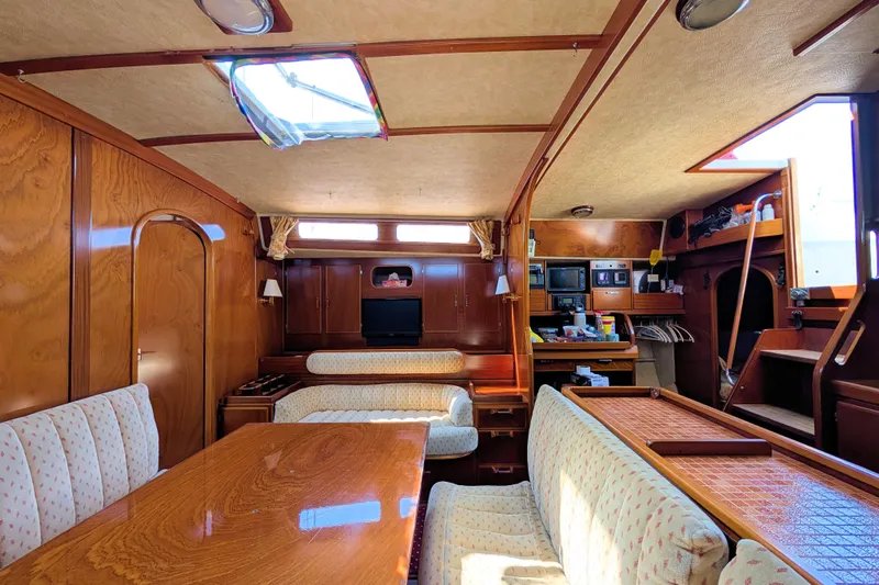 Iteration Yacht Photos Pics Interior of 1994 Amel 53 Super Maramu yacht with wood finish and cozy seating area.