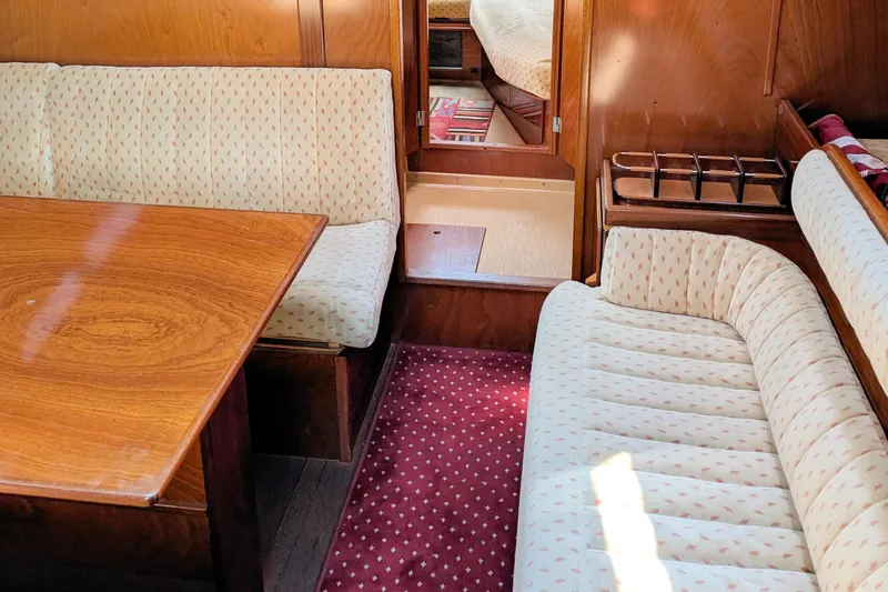 Iteration Yacht Photos Pics Interior of 1994 Amel 53 Super Maramu yacht with cozy seating and wooden table.