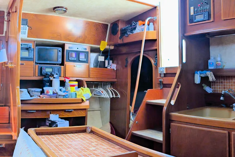 Iteration Yacht Photos Pics Interior of 1994 Amel 53 Super Maramu yacht with wooden cabinetry and kitchen amenities.