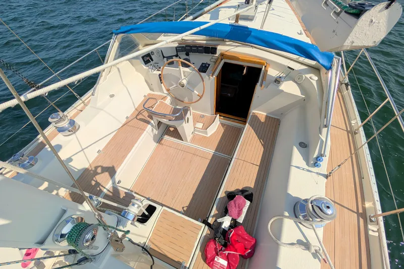 Iteration Yacht Photos Pics Cockpit of 1994 Amel 53 Super Maramu sailboat with wooden deck and steering wheel.