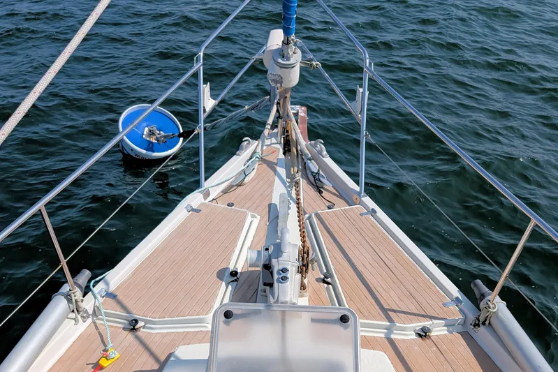 Iteration Yacht Photos Pics Bow of 1994 Amel 53 Super Maramu sailboat on water, with blue buoy nearby.