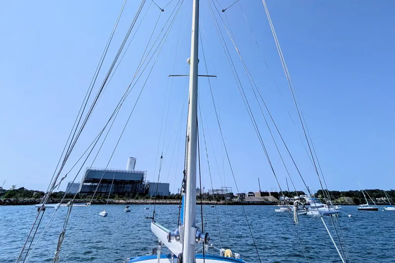 Iteration Yacht Photos Pics Sailboat mast view from 1994 Amel 53 Super Maramu on calm water, clear sky.