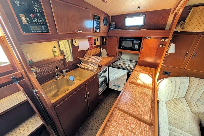 Iteration Yacht Photos Pics Interior of 1998 Amel 53 Super Maramu yacht kitchen with wood cabinetry and appliances.