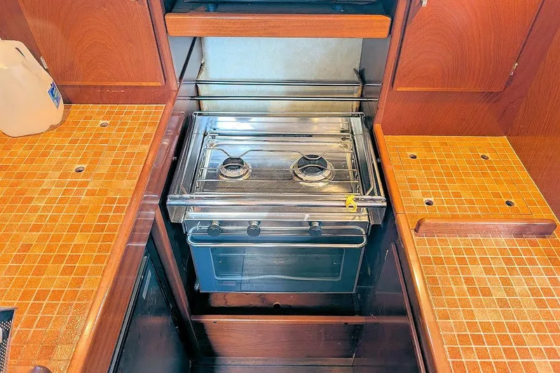 Iteration Yacht Photos Pics Galley kitchen in 1998 Amel 53 Super Maramu yacht with stove and tiled countertops.