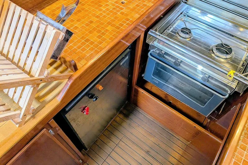 Iteration Yacht Photos Pics 1998 Amel 53 Super Maramu yacht kitchen with stove and wooden flooring.