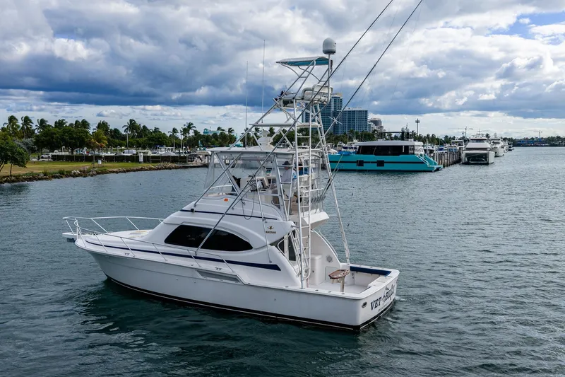 Vet Billz Yacht Photos Pics 2001 Bertram 390 yacht cruising near a marina under a cloudy sky.