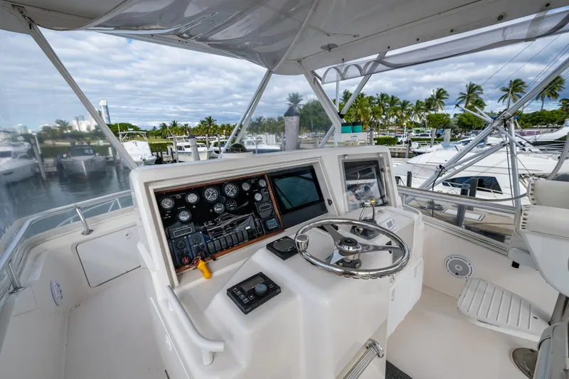 Vet Billz Yacht Photos Pics Helm of 2001 Bertram 390 yacht with steering wheel and control panel, docked at marina.