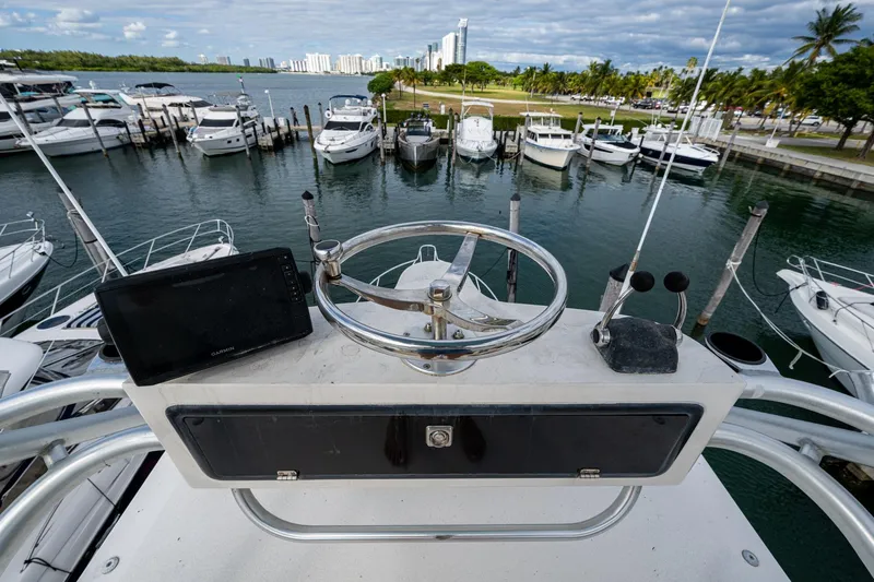 Vet Billz Yacht Photos Pics Helm of a 2001 Bertram 390 yacht overlooking marina with docked boats.