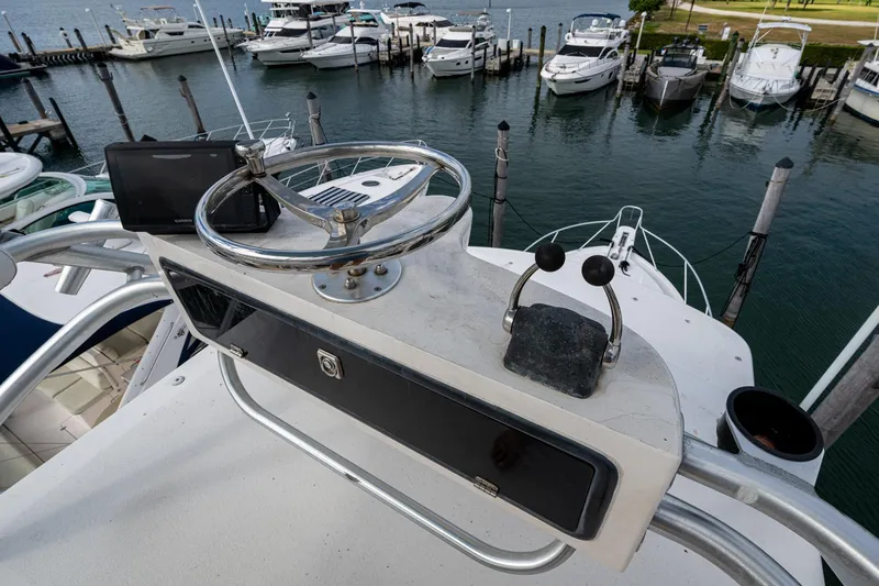 Vet Billz Yacht Photos Pics Helm of 2001 Bertram 390 yacht overlooking marina with docked boats.