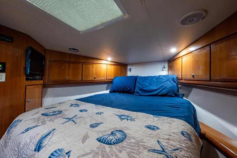 Vet Billz Yacht Photos Pics Cozy cabin interior of 2001 Bertram 390 yacht with wooden cabinets and nautical bedding.