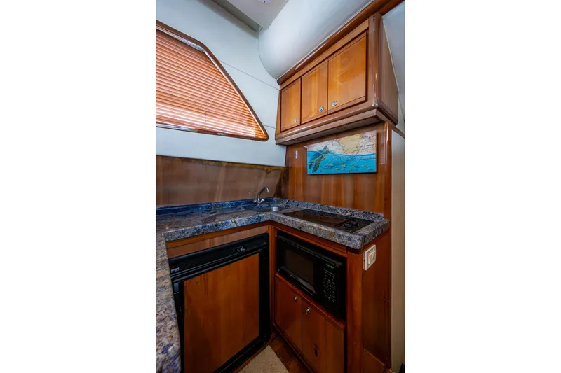 Vet Billz Yacht Photos Pics Compact kitchen in 2001 Bertram 390 yacht with wooden cabinets and modern appliances.