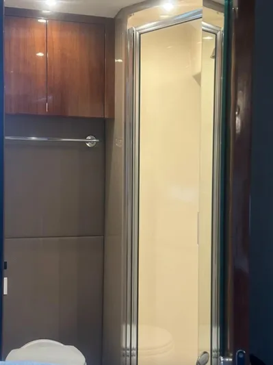  Yacht Photos Pics Modern bathroom interior with wooden cabinets and glass shower door in a 2016 Carver C43 Coupe.