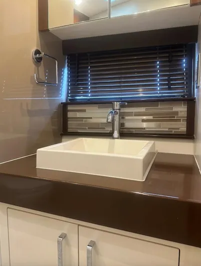  Yacht Photos Pics Modern bathroom sink with brown countertop, stylish backsplash, and window blinds in a 2016 Carver C43 Coupe.