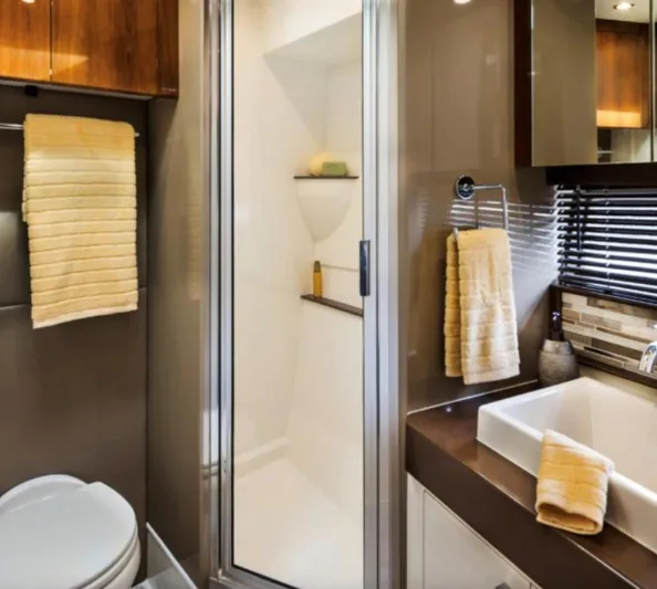  Yacht Photos Pics Modern bathroom with shower, sink, and yellow towels in a 2016 Carver C43 Coupe.