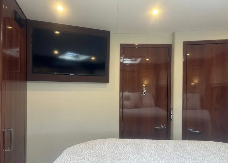  Yacht Photos Pics Interior of 2016 Carver C43 Coupe with TV, wooden doors, and cozy bedding.