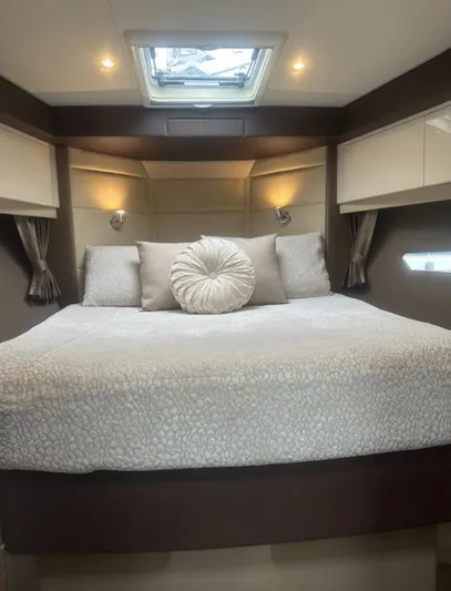  Yacht Photos Pics Luxurious bedroom interior in a 2016 Carver C43 Coupe yacht, featuring elegant bedding and ambient lighting.