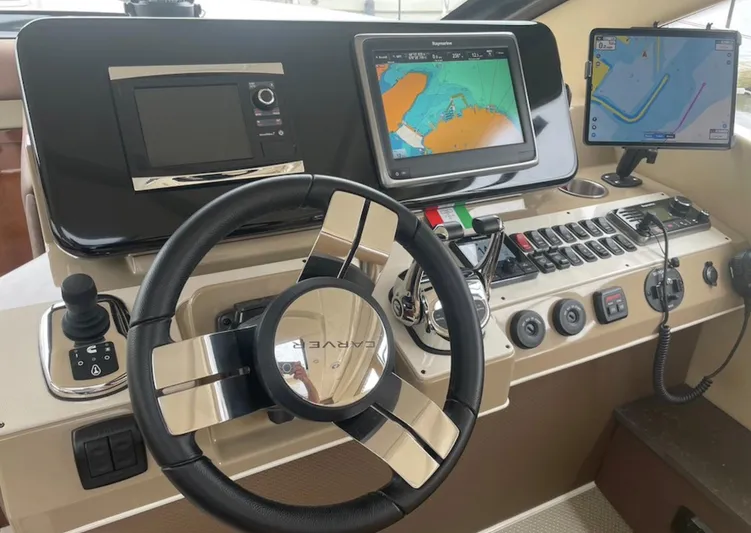  Yacht Photos Pics Control panel of a 2016 Carver C43 Coupe with navigation screens and steering wheel.
