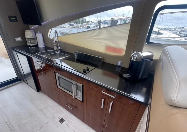  Yacht Photos Pics Modern kitchen interior in a 2016 Carver C43 Coupe yacht, featuring sleek appliances and wood cabinetry.