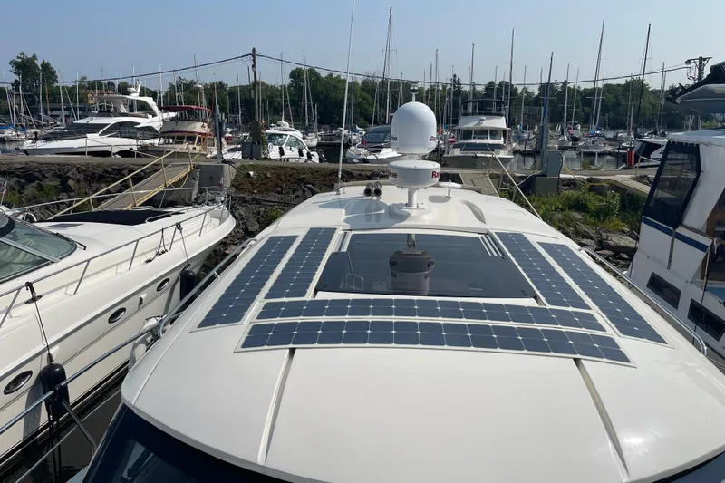  Yacht Photos Pics Boat with solar panels docked at a marina, surrounded by other yachts.