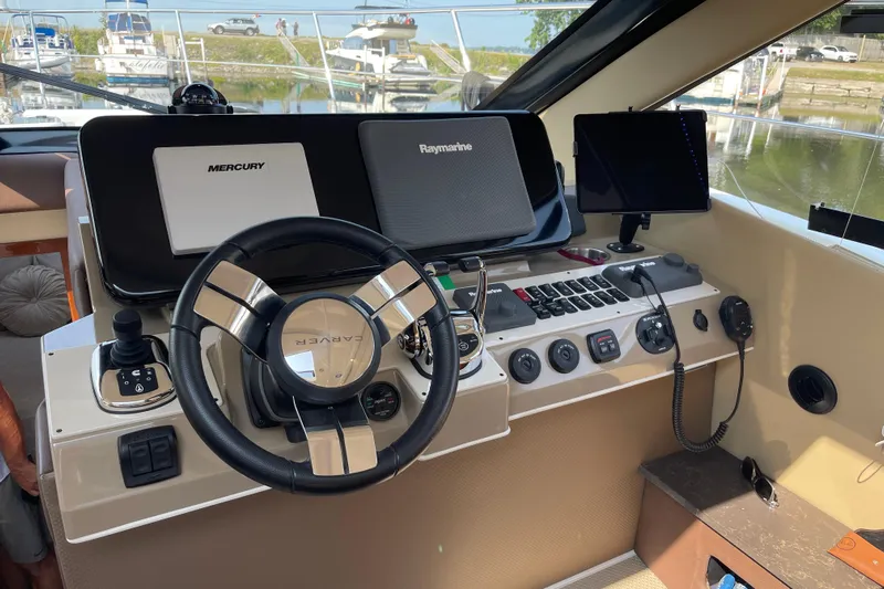  Yacht Photos Pics 2016 Carver C43 Coupe helm with Mercury and Raymarine controls, docked near boats.