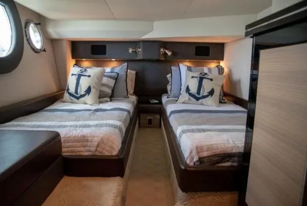 Why Knot Yacht Photos Pics 2011 Marquis Sport Coupe cabin with twin beds, nautical-themed pillows, and modern decor.