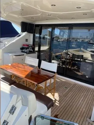 Why Knot Yacht Photos Pics 2011 Marquis Sport Coupe yacht with elegant deck seating and wooden table.