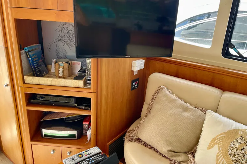  Yacht Photos Pics Interior of 2003 Silverton 38 Convertible yacht with TV, shelves, and cozy seating area.