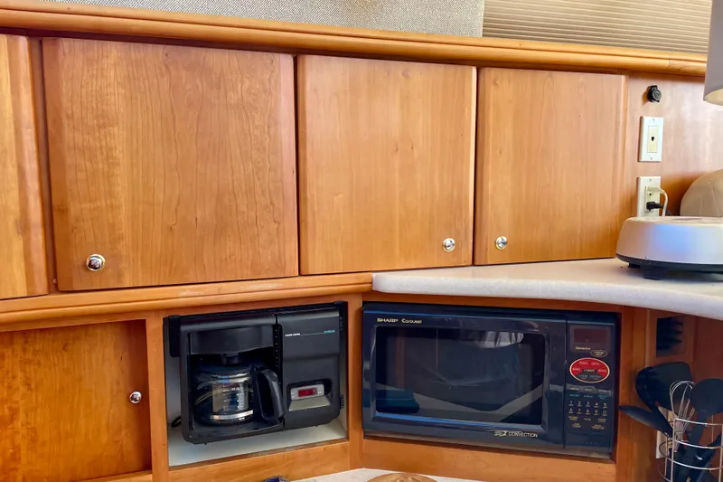  Yacht Photos Pics 2003 Silverton 38 Convertible kitchen with wooden cabinets, microwave, and coffee maker.
