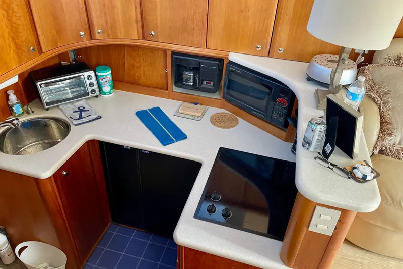  Yacht Photos Pics 2003 Silverton 38 Convertible yacht kitchen with sink, appliances, and wooden cabinetry.