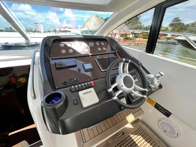 El Andariego Yacht Photos Pics Helm of 2008 Sunseeker Portofino 47 yacht with steering wheel and navigation controls.