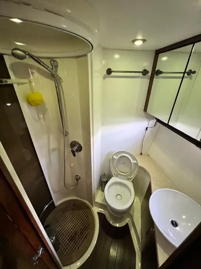El Andariego Yacht Photos Pics Bathroom interior of 2008 Sunseeker Portofino 47 yacht with shower, toilet, and sink.