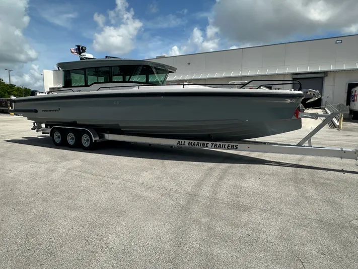  Yacht Photos Pics 2020 Axopar 37 XC CROSS CABIN boat on trailer, parked outdoors.