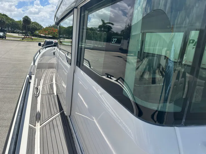  Yacht Photos Pics 2020 Axopar 37 XC CROSS CABIN boat side view with sleek design and reflective windows.