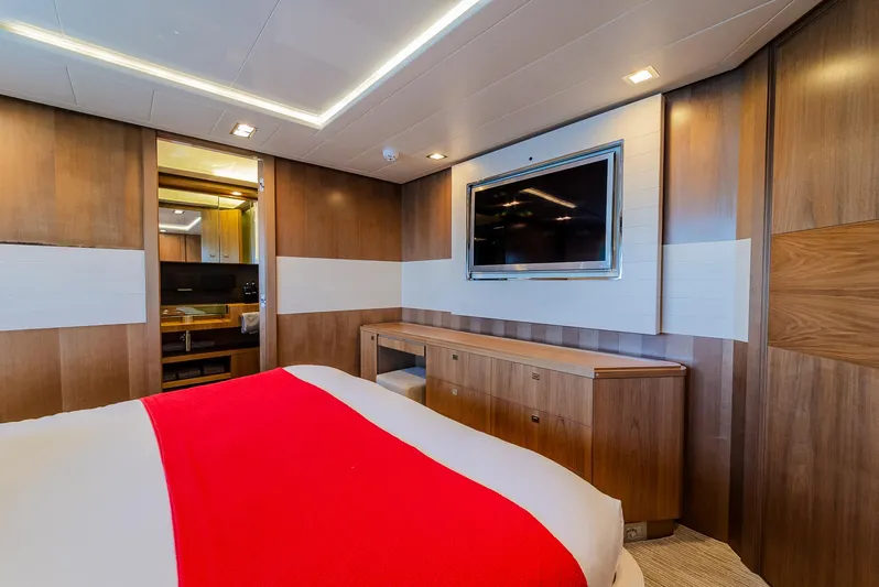 One And Only Yacht Photos Pics Luxurious yacht bedroom with wood paneling, red bedspread, and wall-mounted TV, Custom Line 100, 2012.